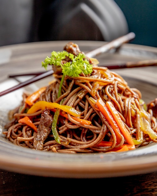 Fideos preparados con carne, pimientos y salsa