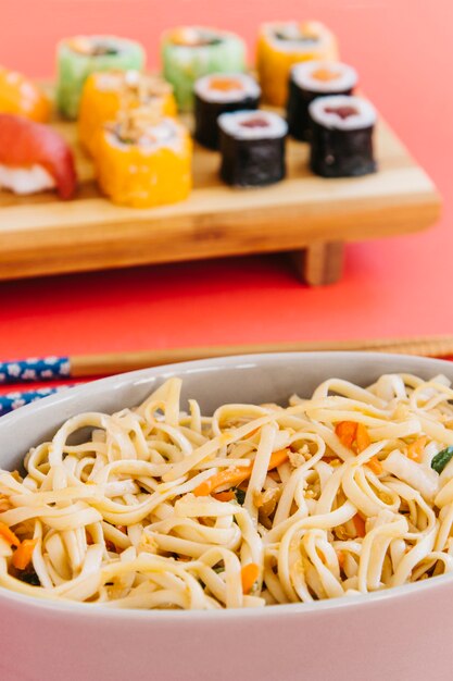 Fideos de primer plano cerca de sushi