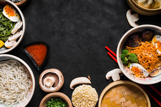 Fideos con salsa y verduras sobre fondo negro