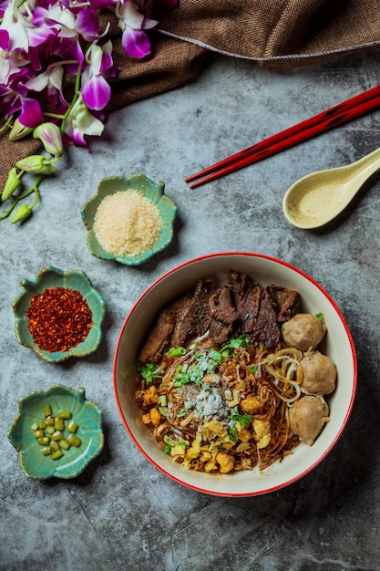 Fideos secos finos con estofado de cerdo y bola de cerdo.