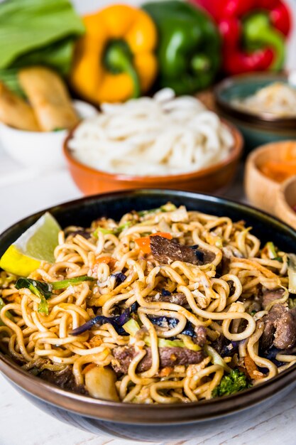 Fideos udon tailandeses con carne y rodaja de limón