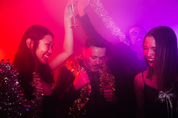 Fiesta de año nuevo en discoteca con grupo de amigos bailando