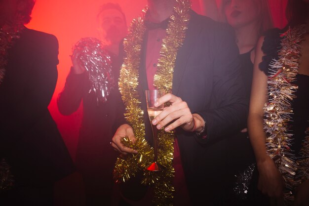 Fiesta de año nuevo en discoteca con hombre sujetando vaso