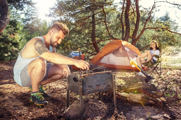 Fiesta, campamento de grupo de hombres y mujeres en el bosque.