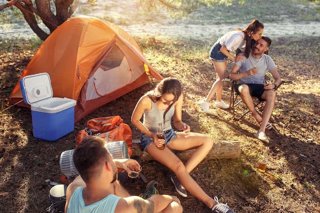 Fiesta, campamento de grupo de hombres y mujeres en el bosque.