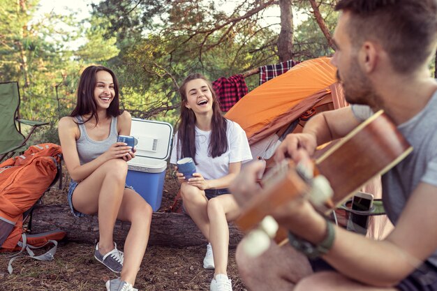 Fiesta, campamento de grupo de hombres y mujeres en el bosque.