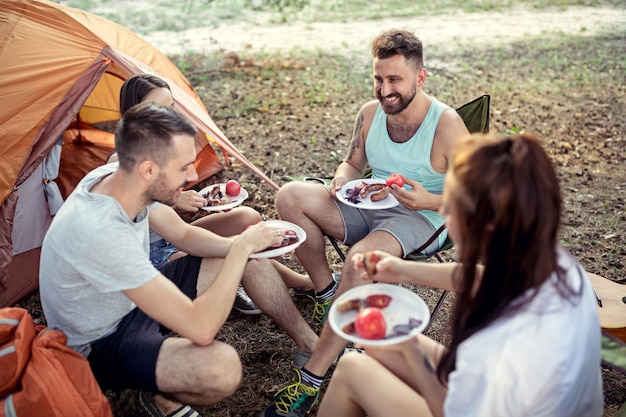 Fiesta, campamento de grupo de hombres y mujeres en el bosque.