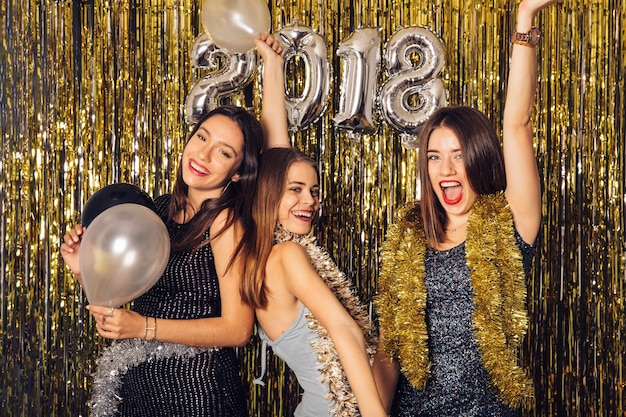 Fiesta de discoteca de año nuevo con tres amigas bailando