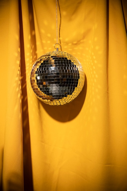Foto gratuita fiesta de globo plateado de ángulo bajo en cortina amarilla