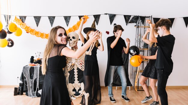 Fiesta de Halloween en habitación decorada con globos y esqueleto