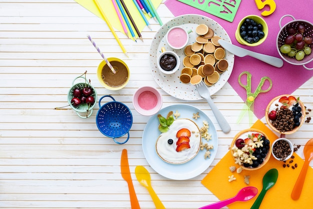 Foto gratuita fiesta de panqueques, comida para niños con bayas frescas y yogur