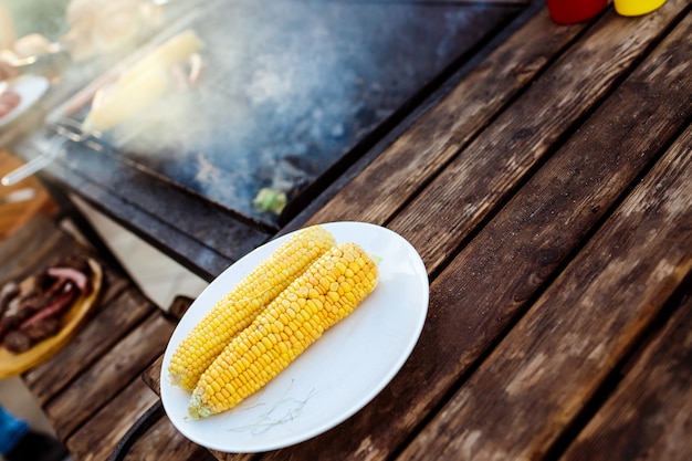 Fiesta de parrilla de barbacoa. Sabroso maíz en plato blanco.