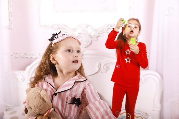 Fiesta de pijamas para niños, niñas vestidas con pijamas brillantes, juego de burbujas