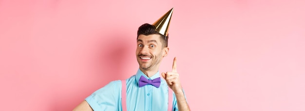 Fiestas y celebraciones imagen conceptual de un hombre feliz con sombrero de fiesta de cumpleaños lanzando una idea planteando f