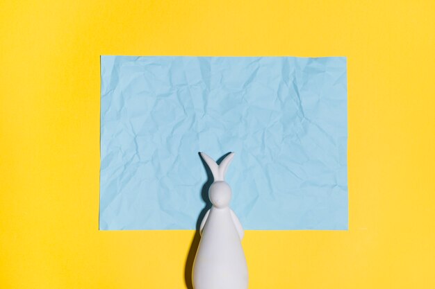 Figura de conejo con papel sobre mesa.
