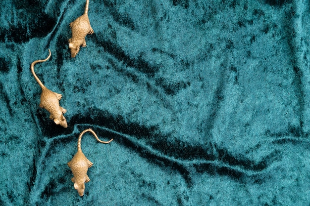 Figura plana de figuras de ratas sobre terciopelo turquesa