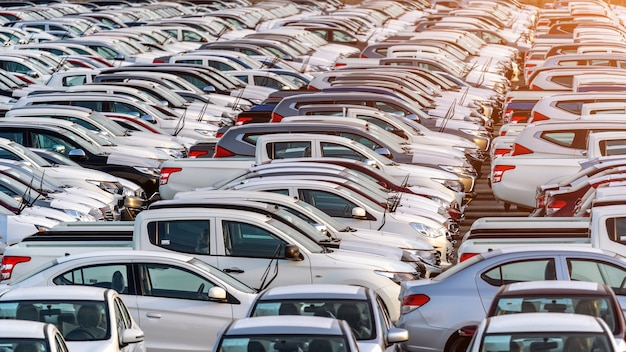 Fila de coches nuevos en el puerto.