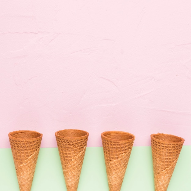 Foto gratuita fila de conos de helado vacíos en superficie multicolor