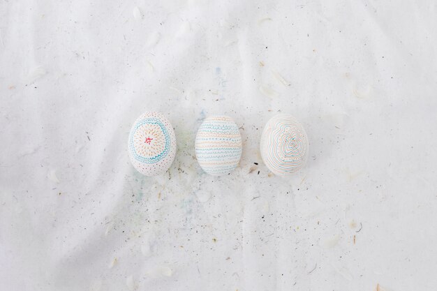 Fila de huevos de Pascua con patrones y plumas en textil