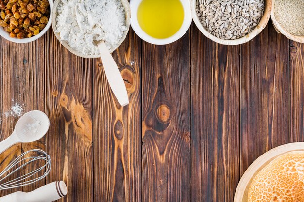 Fila de ingredientes para hornear en la mesa de madera