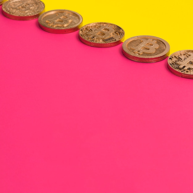 Fila de muchos bitcoins sobre el fondo doble amarillo y rosa