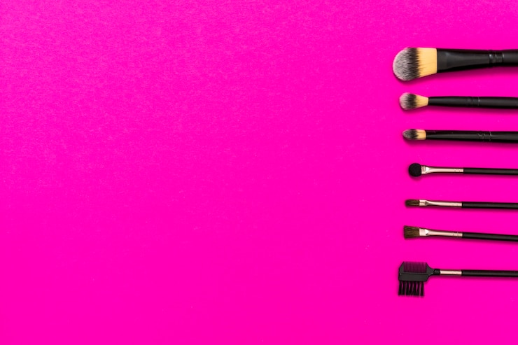 Foto gratuito fila de pinceles de maquillaje con espacio de copia para escribir el texto sobre fondo rosa