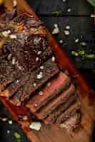 Foto gratuita filete de carne cruda cocida en rodajas y sal agregada, servida en la mesa negra