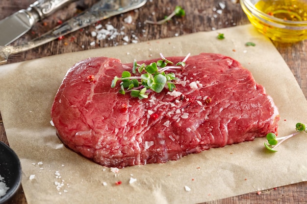 Filete de carne fresca en el tablero de madera antiguo Fondo oscuro Primer plano