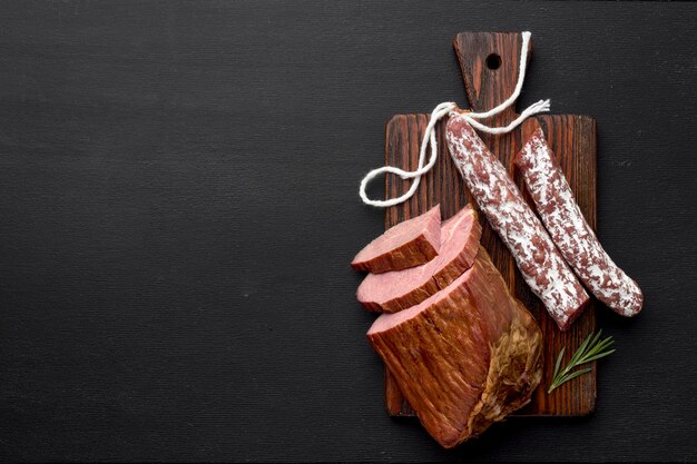 Filete de carne y salami sobre tabla de madera