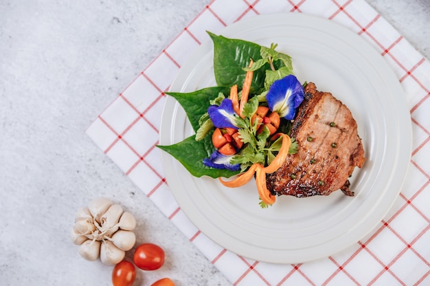 Filete de cerdo con tomate, zanahoria, cebolla morada, menta, flor de guisante y lima.