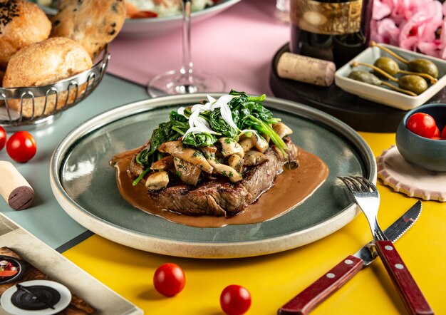 Filete de cordero cubierto con champiñones salteados y espinacas