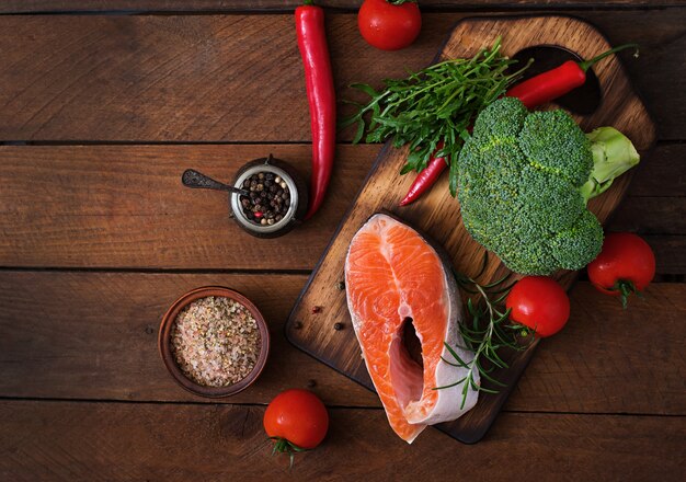 Filete crudo salmón y verduras para cocinar en la mesa de madera en un estilo rústico. Vista superior