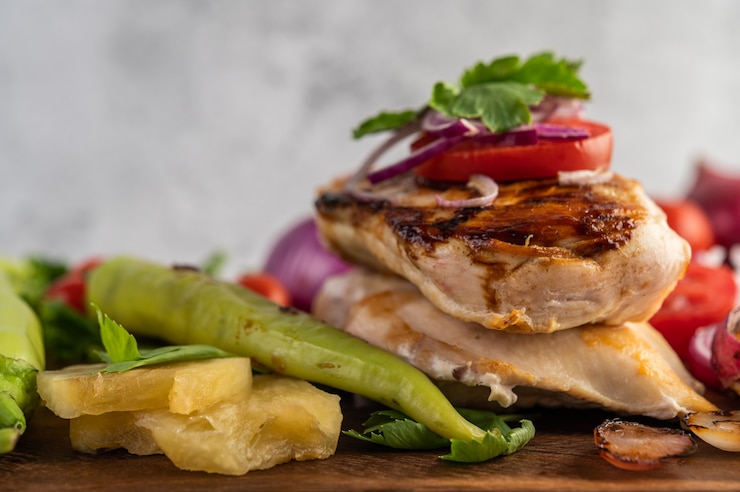 Foto gratuito filete de pollo colocado en una bandeja de madera.