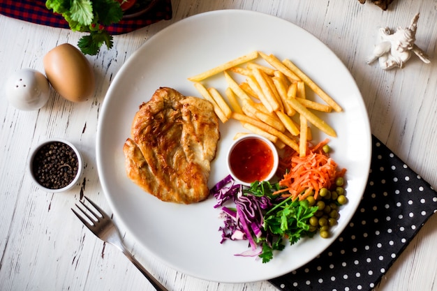 Filete de pollo frito con papas fritas y chile dulce