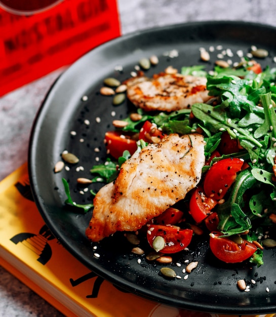 Filete de pollo frito con tomate y hierbas.