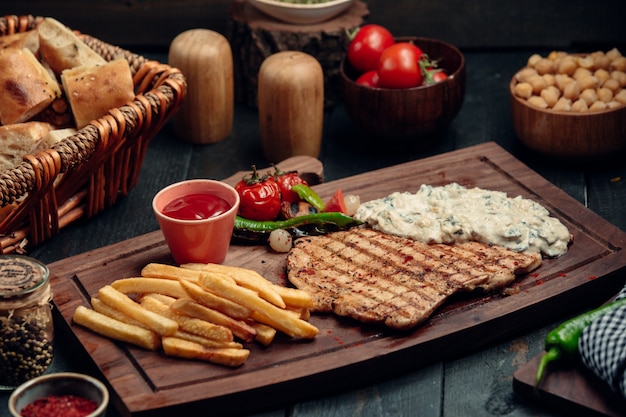 filete de pollo a la parrilla con cremosa salsa de champiñones, papas fritas y salsa de tomate