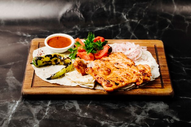 Filete de pollo a la parrilla en lavash con pimiento verde a la parrilla, tomate y salsa roja.