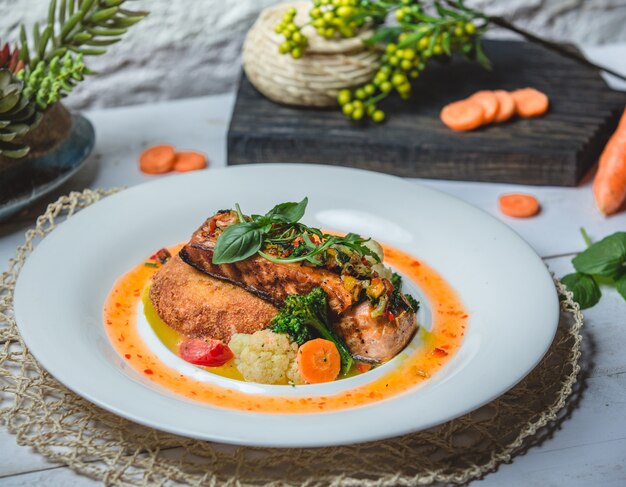 Filete de pollo a la parrilla en salsa de vegetales y hierbas.