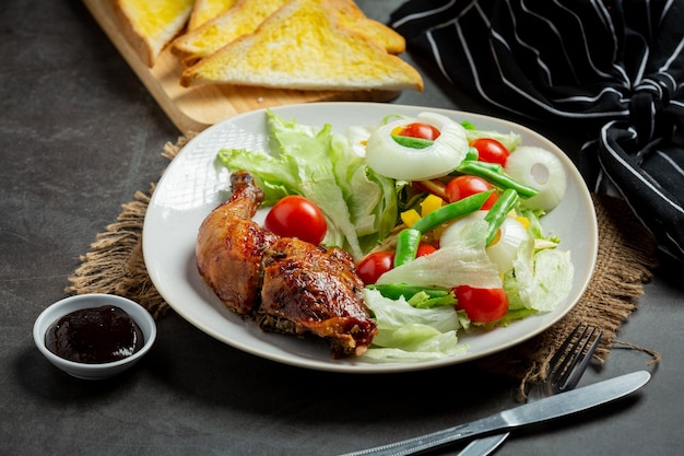 Filete de pollo a la plancha y verduras sobre fondo oscuro