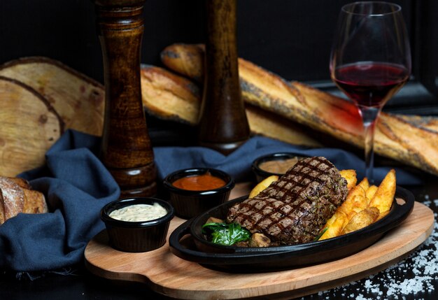 Filete de res con papas fritas, mayonesa, mostaza y ketchup