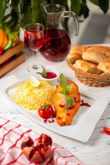 Filete de salmón blanco a la plancha con guarnición basílica, tomate y arroz.