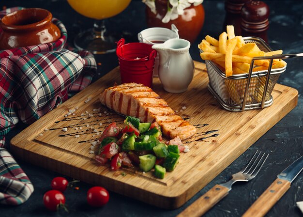 filete de salmón a la parrilla con papas fritas, mayonesa, salsa de tomate y ensalada fresca