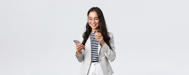 Finanzas empresariales y empleo concepto de emprendedoras exitosas mujer empresaria asiática profesional en vasos almorzando bebiendo café para llevar y usando teléfono móvil