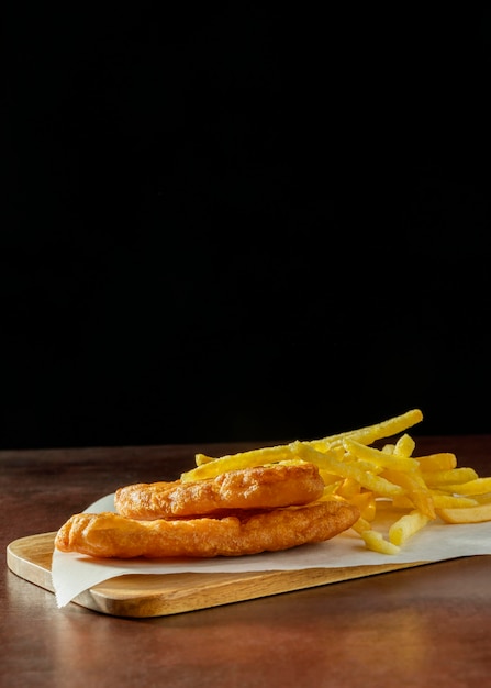 Fish and chips en una tabla de cortar con espacio de copia