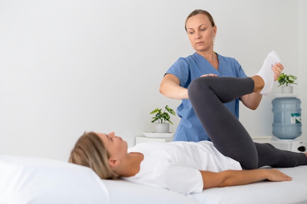 Fisioterapeuta ayudando a una paciente joven en su clínica