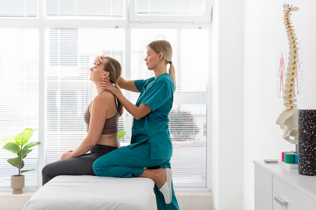 Fisioterapeuta ayudando a un paciente en su clínica
