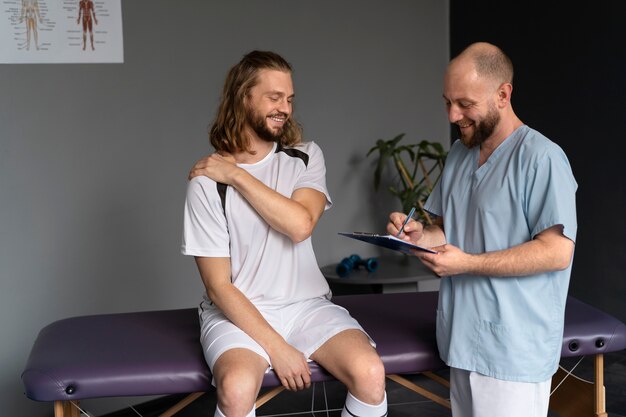 Fisioterapeuta ayudando a la vista lateral del paciente