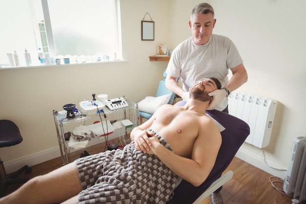 Fisioterapeuta examinando el cuello de un paciente