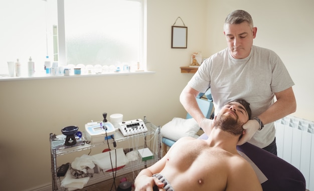 Foto gratuita fisioterapeuta examinando el cuello de un paciente