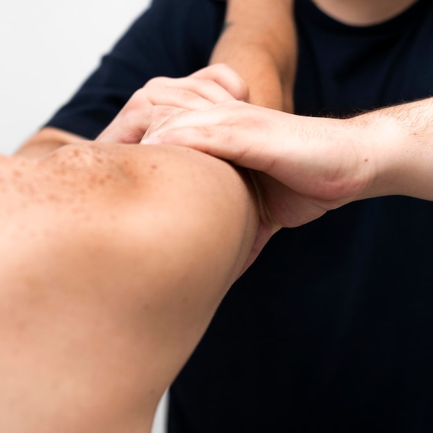 Fisioterapeuta masajeando el brazo del hombre